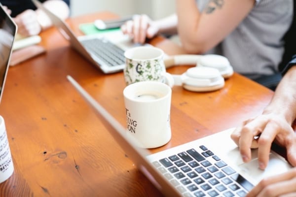 People working next to each other at a dining table. Choice of HR-Technology.