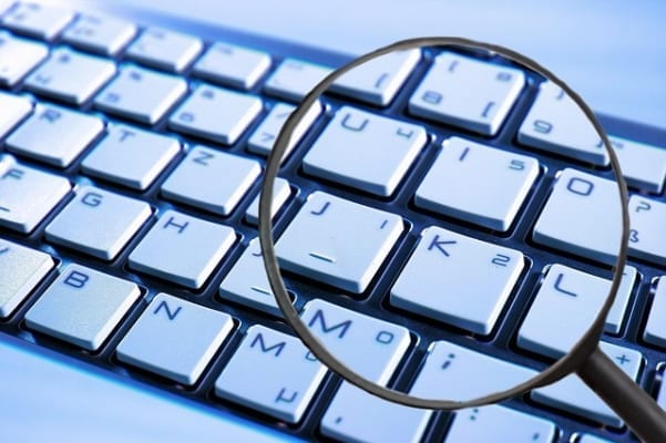 Magnifying glass above keyboard. Sariba HR Data Protection Controll