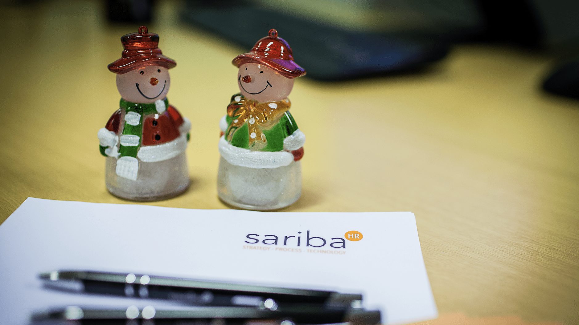 Two Santa Figus standing on a Sariba note sheet