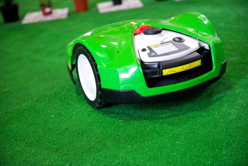 a robotic lawn mower working on a green grass fiel YRECT5F